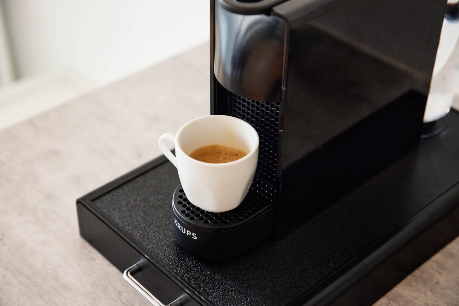 IDEE Living - Eine Kaffeemaschine mit einer Tasse Kaffee darauf.