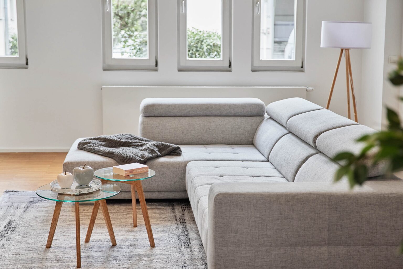 IDEE Living - Ein Wohnzimmer mit einer grauen Couch und einem Couchtisch.