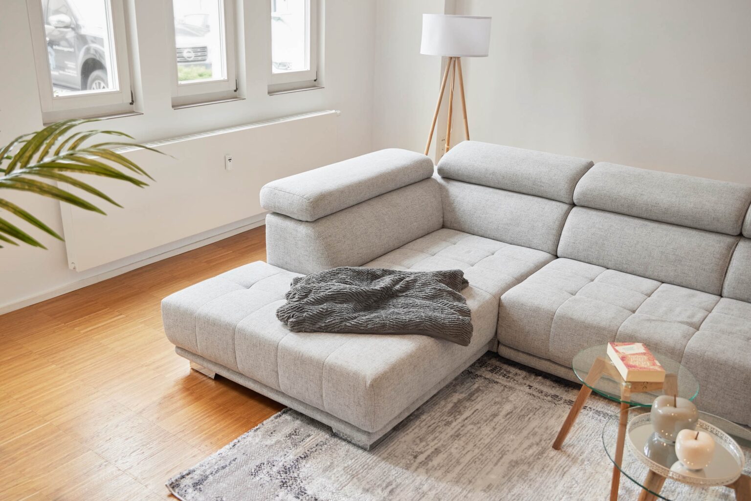 IDEE Living - Ein graues Sofagarnitur in einem Wohnzimmer.