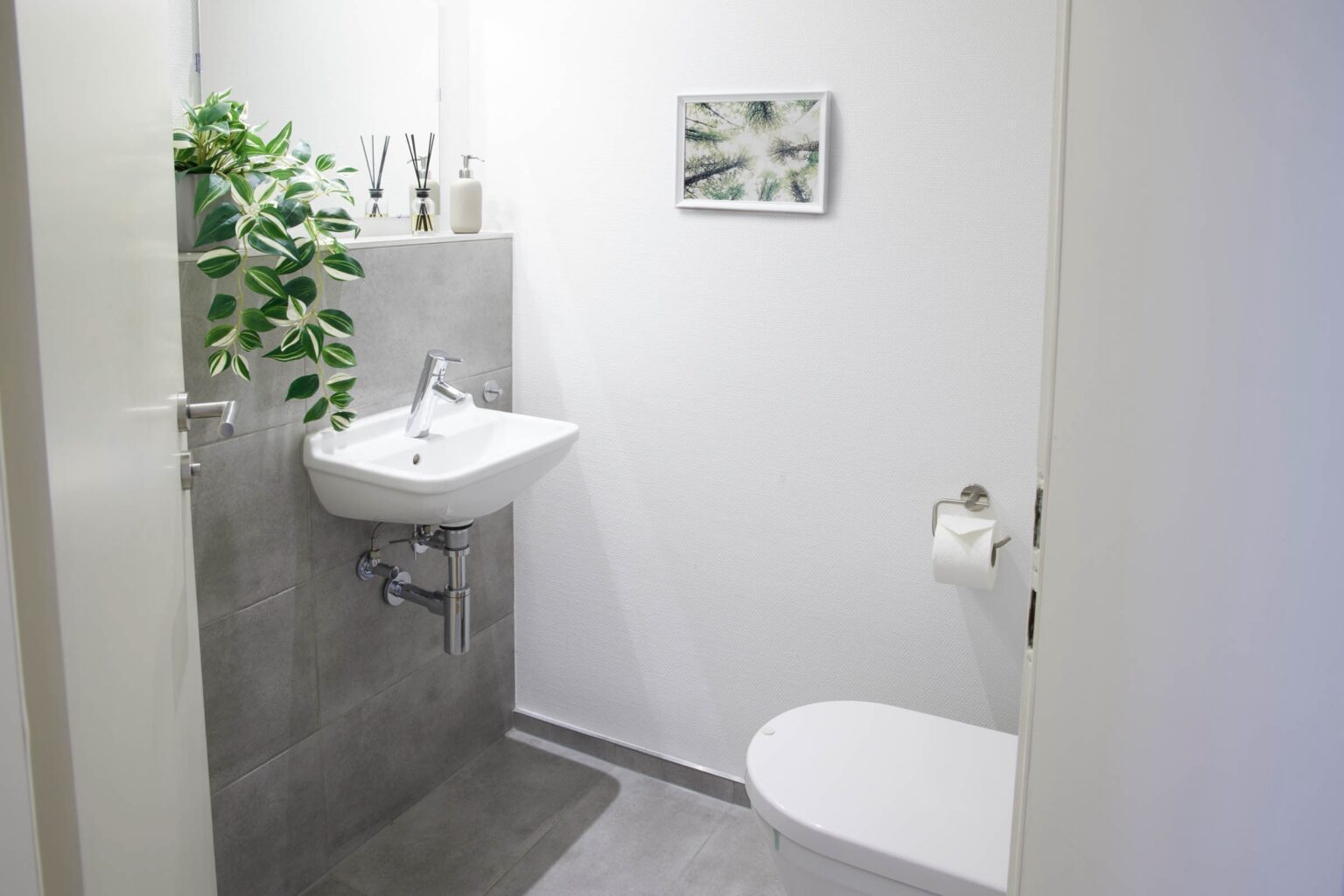 IDEE Living - Ein kleines Badezimmer mit Waschbecken und einer Pflanze.