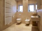 IDEE Living - Ein Badezimmer mit Toilette, Waschbecken und Fenster.