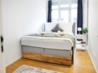 IDEE Living - Ein kleines Schlafzimmer mit einem Bett und einem Nachttisch.